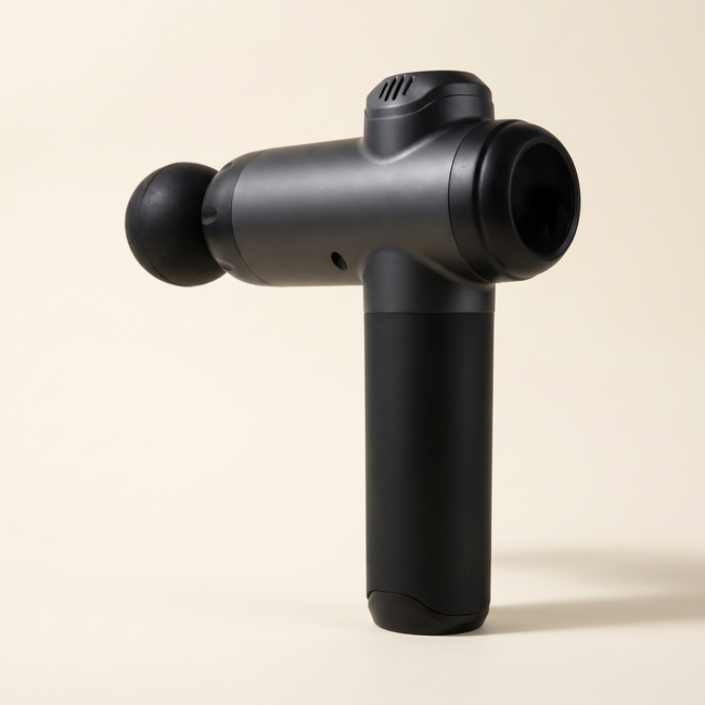Illustrative matte black handheld massage gun with a ball attachment